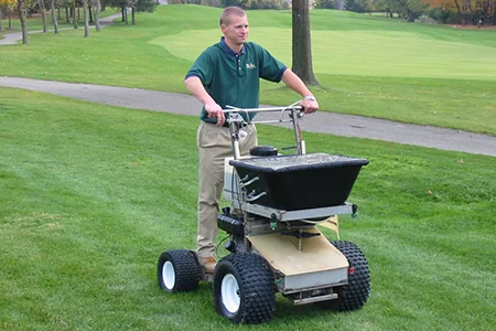 technician fertilizing lawn