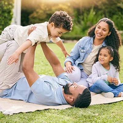 family laying on grass