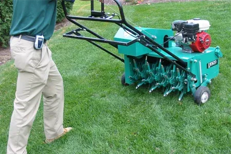 technician aerating lawn