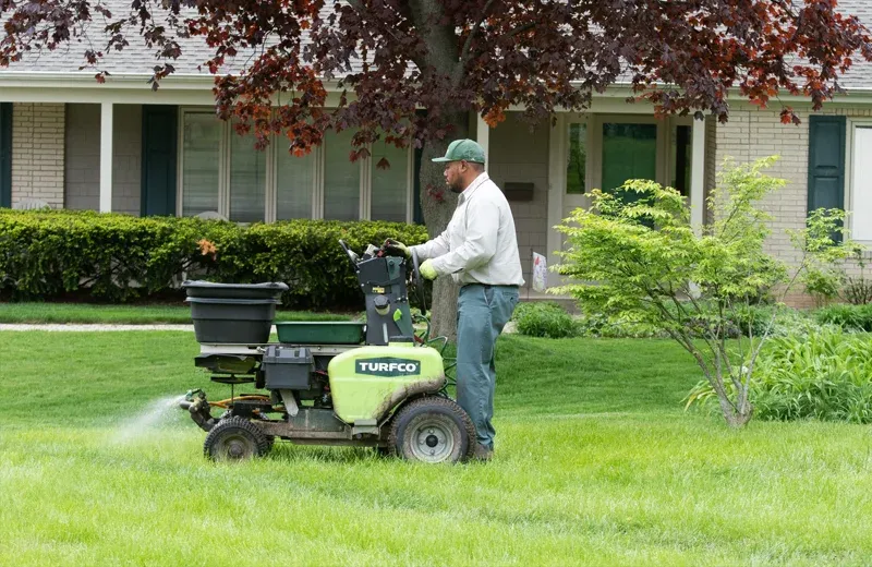 Lawn technician fertilizing lawn