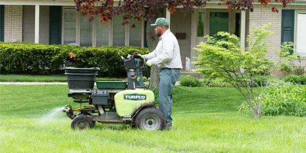 lawn care, technician fertilizing lawn